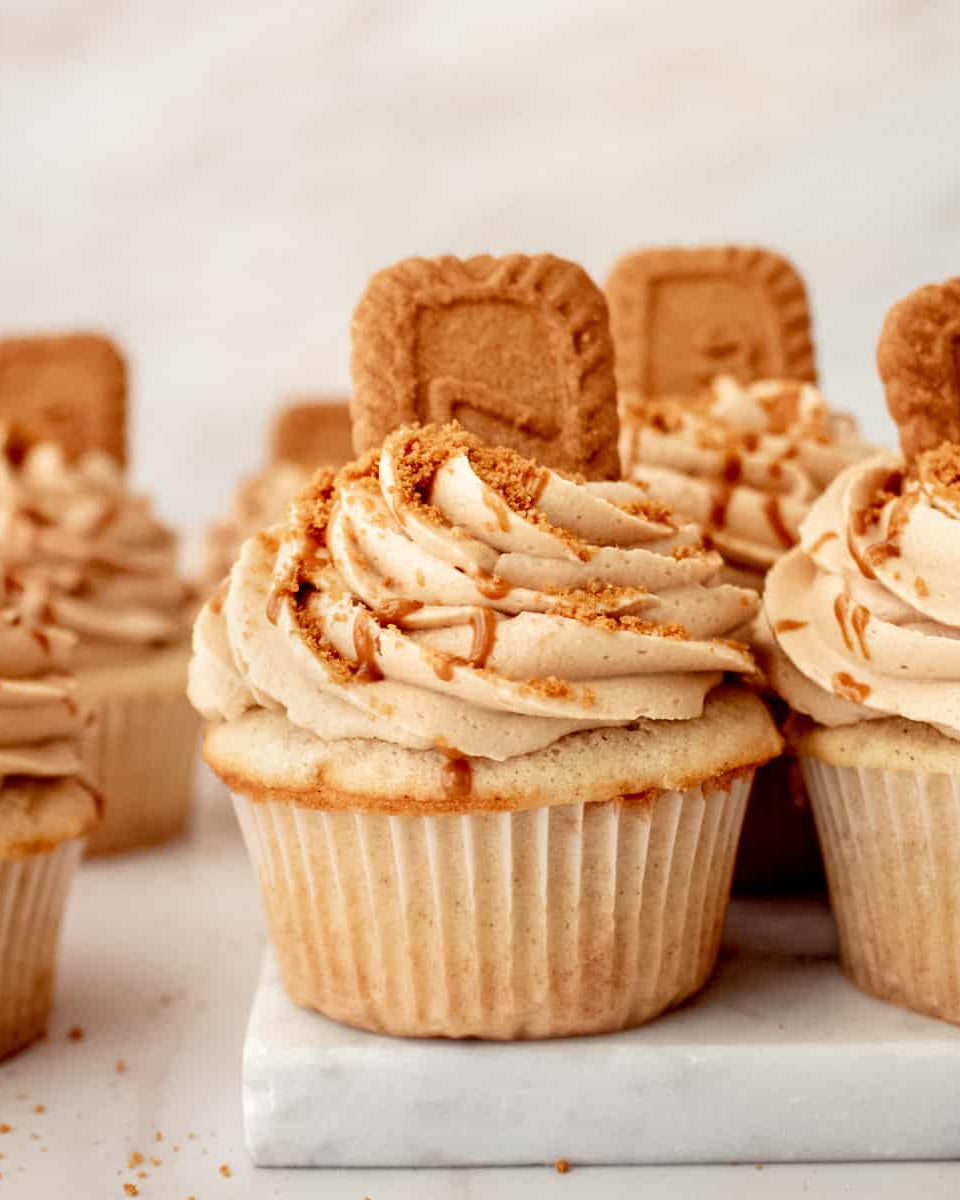 Cupcakes with biscoff frosting and cookies on a marble surface